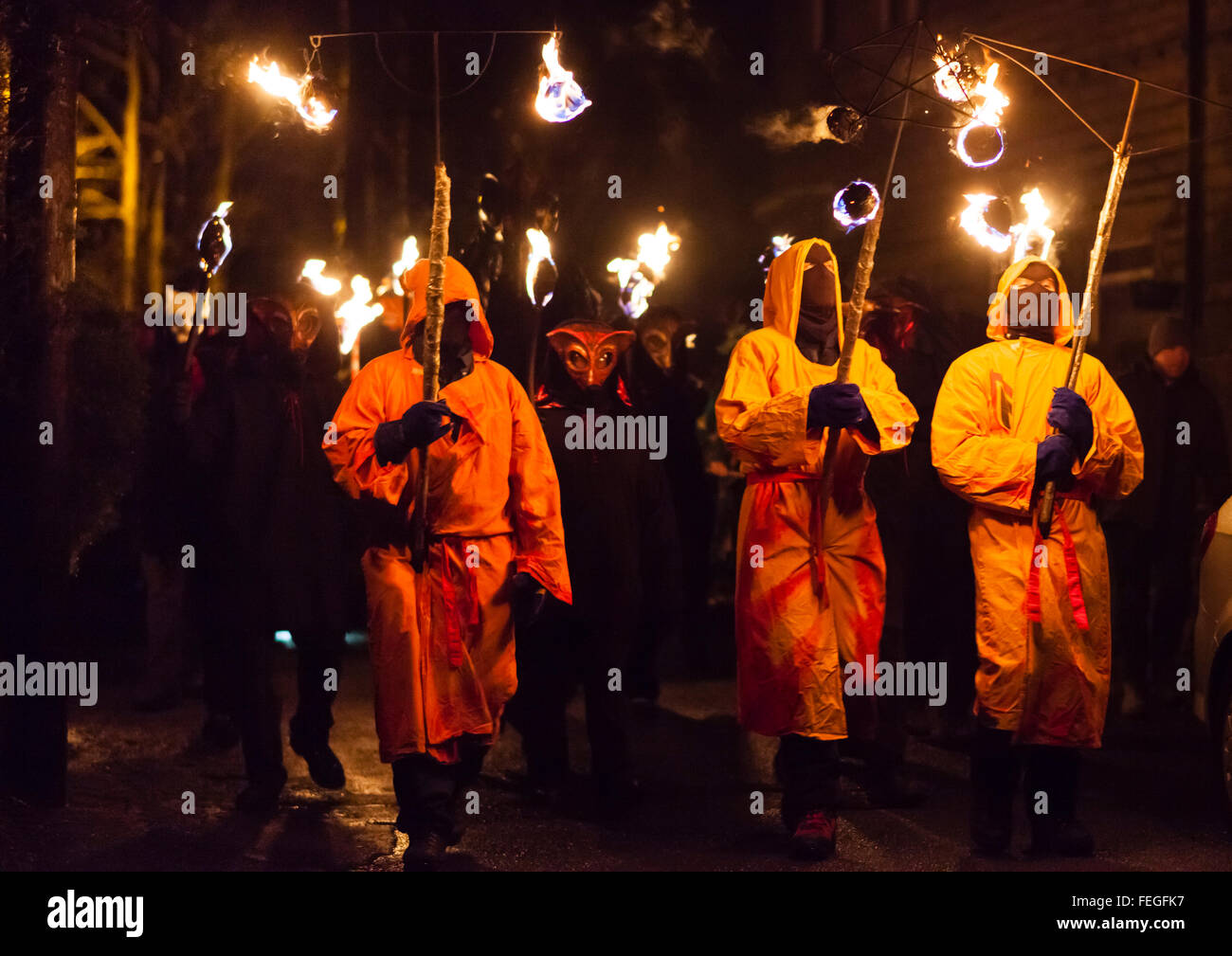 Masked figures lead a torchlight procession for the Imbolc Fire Festival, Marsden, UK Stock Photo