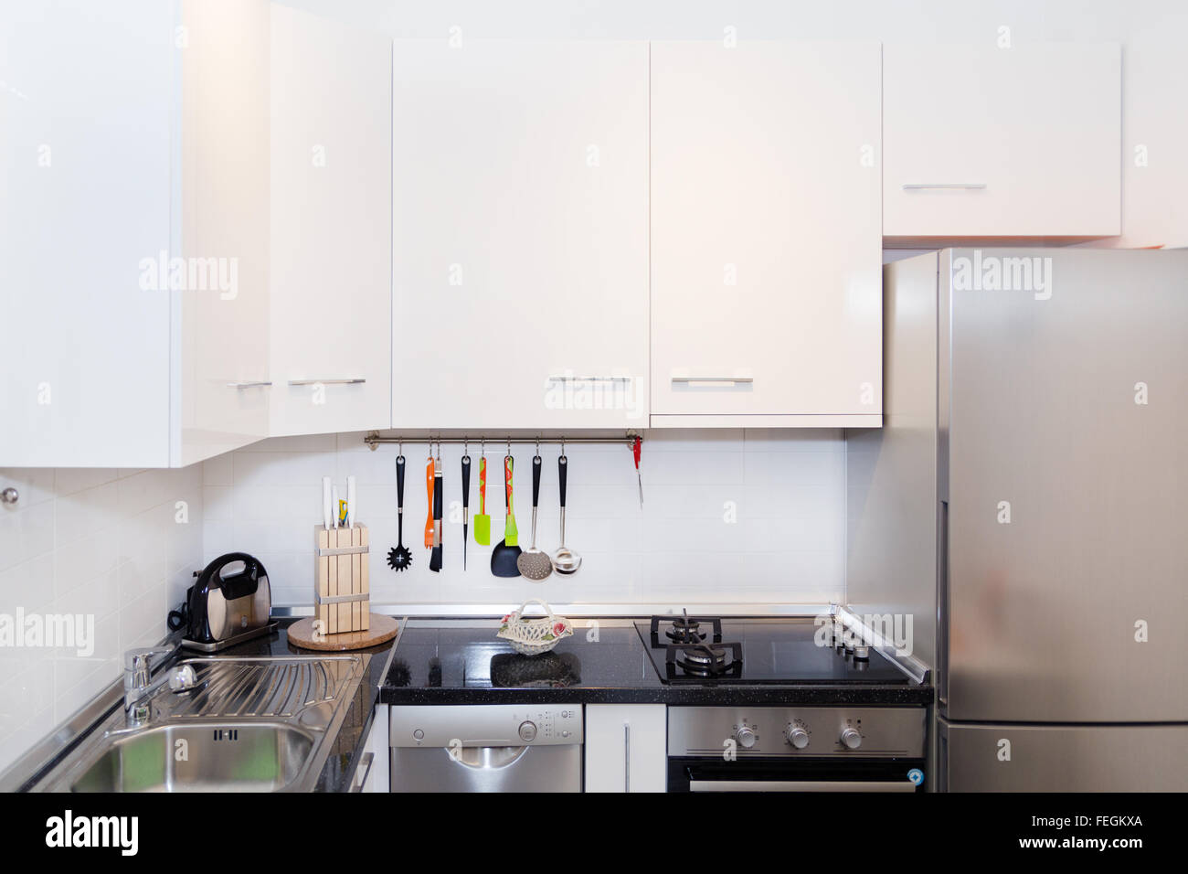 Interior of Small White Kitchen. Bright Modern Kitchen Interior Background. Must Have Kitchenware and Appliances, Stainless Stee Stock Photo