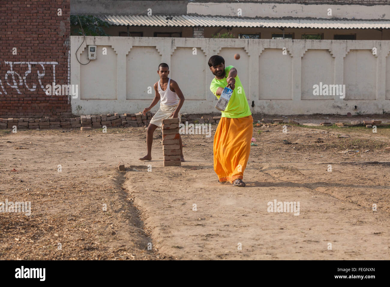 Hariom Sharma, who was taken as a orphan in an Ashram in Agra, India is batting in a makeshift game of cricket. Stock Photo