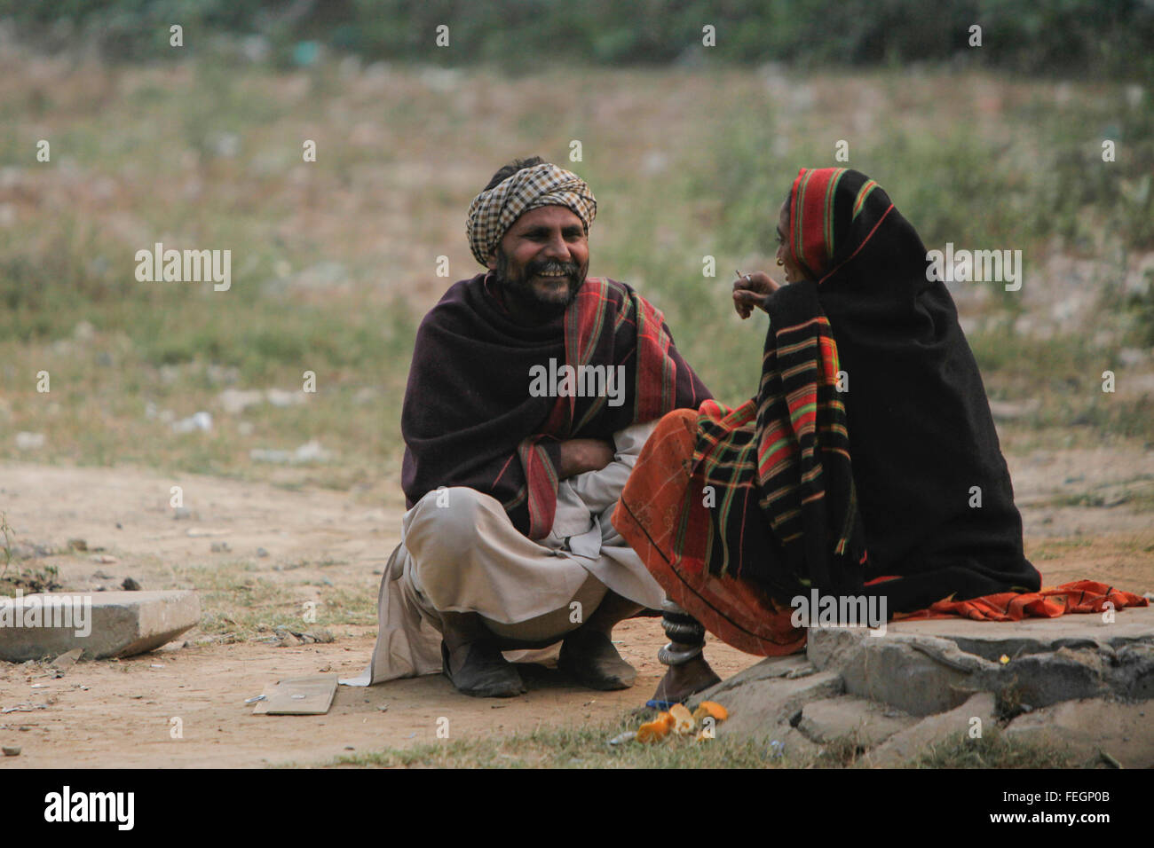 Couple resting after a hard day's work who are a part of India's illiterate women working as laborers using their hands. Stock Photo