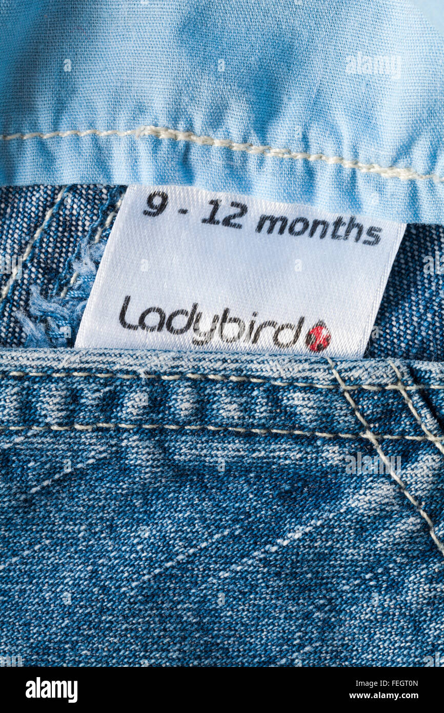 9-12 months Ladybird label in toddlers denim dungarees Stock Photo
