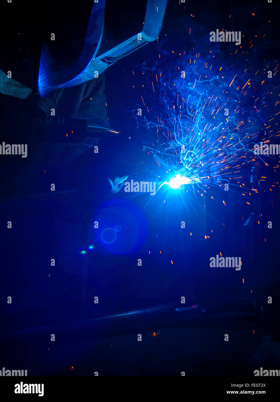 Close-up of welder with protective mask in the factory Stock Photo