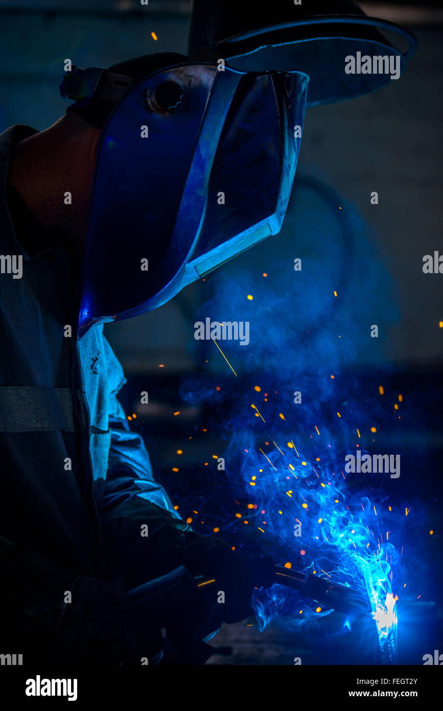 Close-up of welder with protective mask in the factory Stock Photo