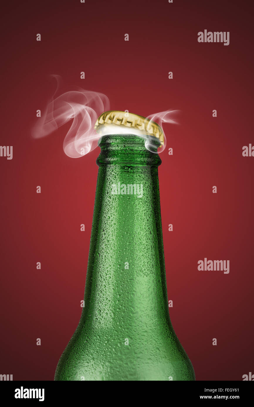 Green cold beer bottle with water drops and golden cap open on red  background Stock Photo - Alamy