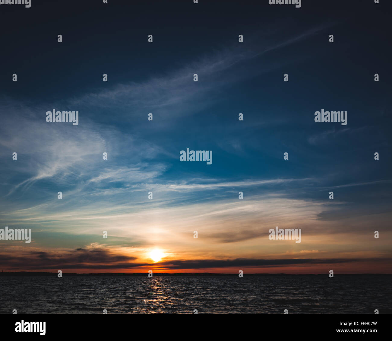 Calm sunset and clouds over lake Stock Photo - Alamy