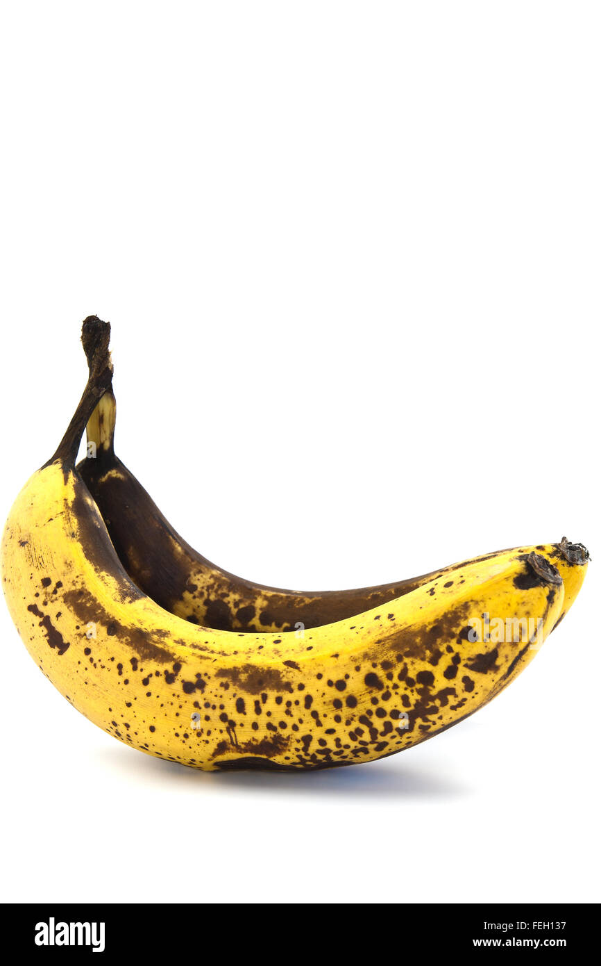 Two overripe bananas with large brown spots on a white background Stock Photo