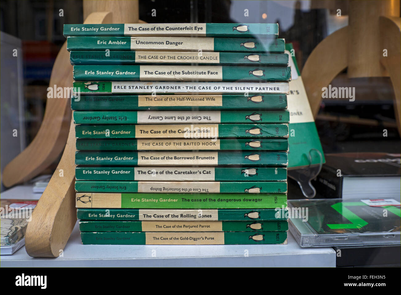 A pile of green penguin "Perry Mason" crime novels by Erle Stanley Gardner, and one by Eric Ambler, in a charity shop window. Stock Photo