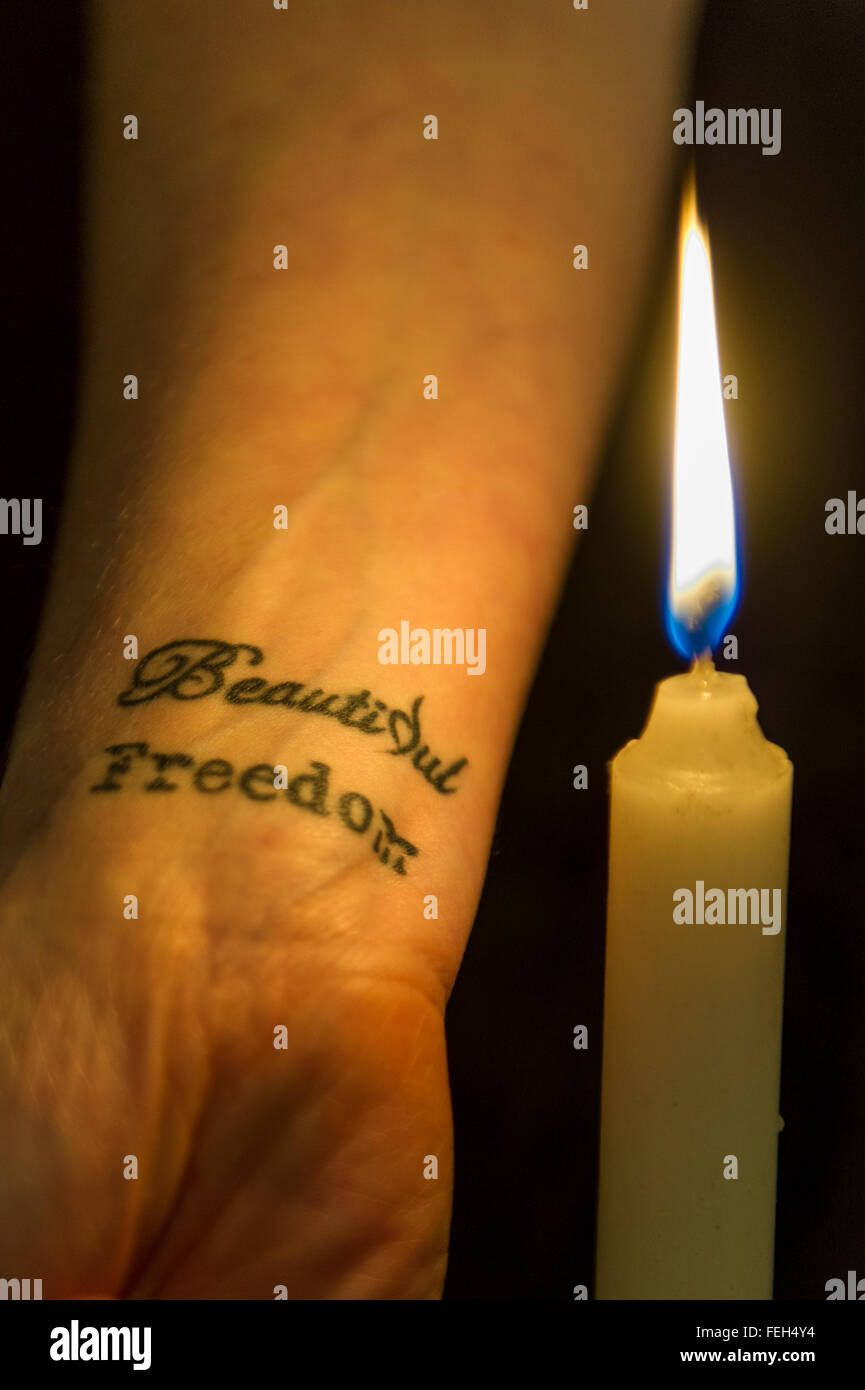 'Beautiful Freedom' tattoo on a woman, signifying the 1916 rising in Ireland and overcoming addiction isolated on black background. Stock Photo