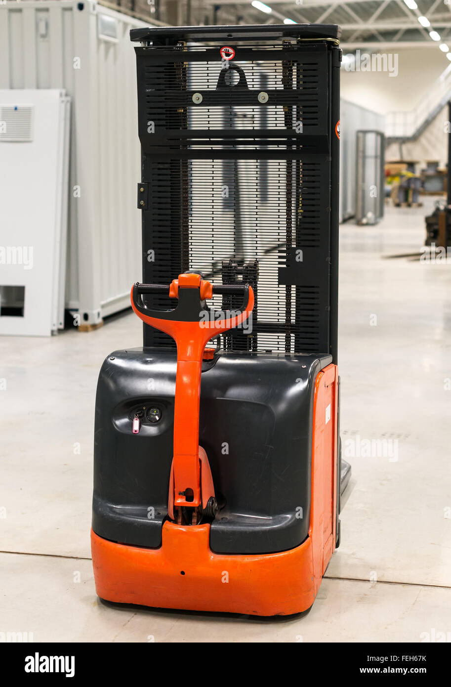 Orange forklift loader in the modern warehouse. Stock Photo