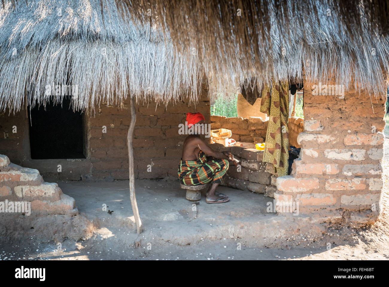 A woman sits alone in the village of Agande on Uno island on the Bijagos archipelago in Guinea Bissau Stock Photo