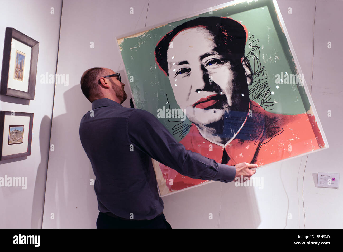 The owner of an art gallery in Manhattan’s Financial District hanging a portrait of Mao Zedong by Andy Warhol. Stock Photo