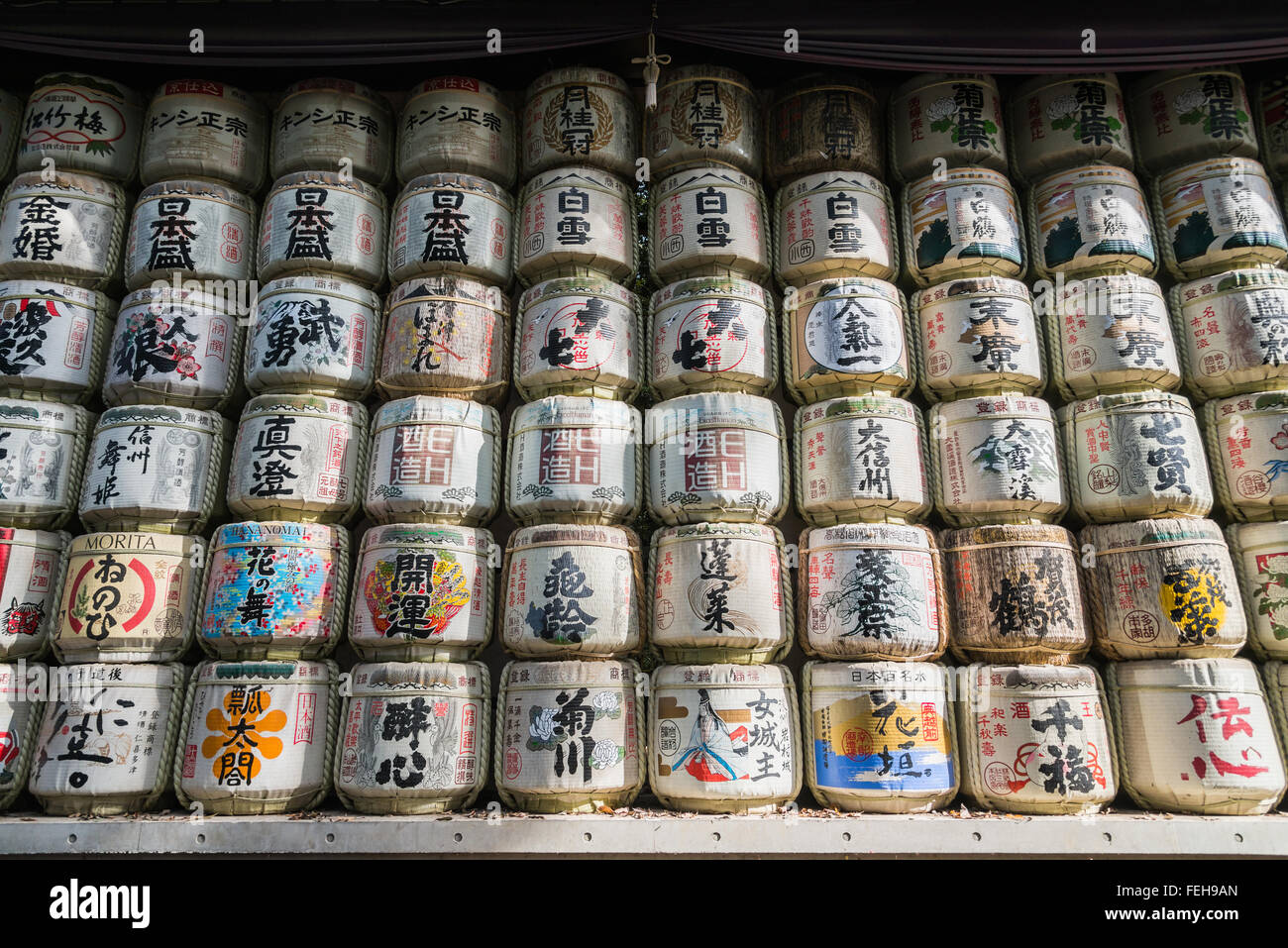 Japanese Barrels of Sake wrapped in Straw stacked on shelf Stock Photo