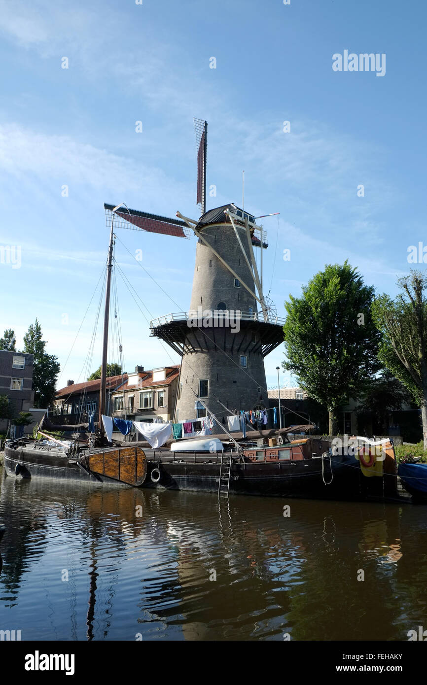 Ships in river port, windmill in background, Gouda, South Holland, The