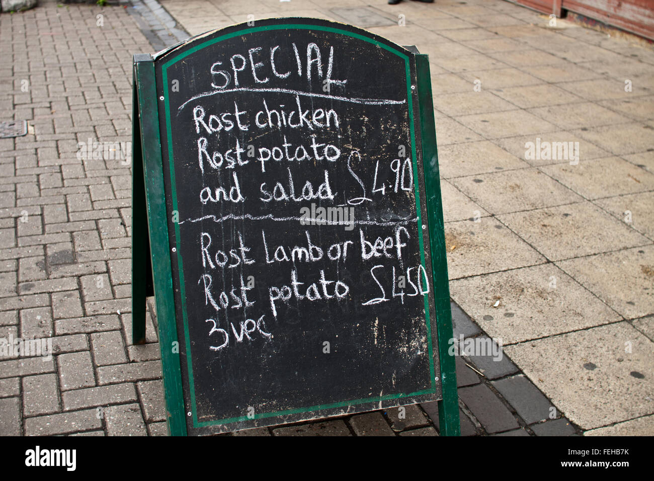 Sign outside café listing specials, with 'roast' spelled incorrectly as 'rost'. Stock Photo