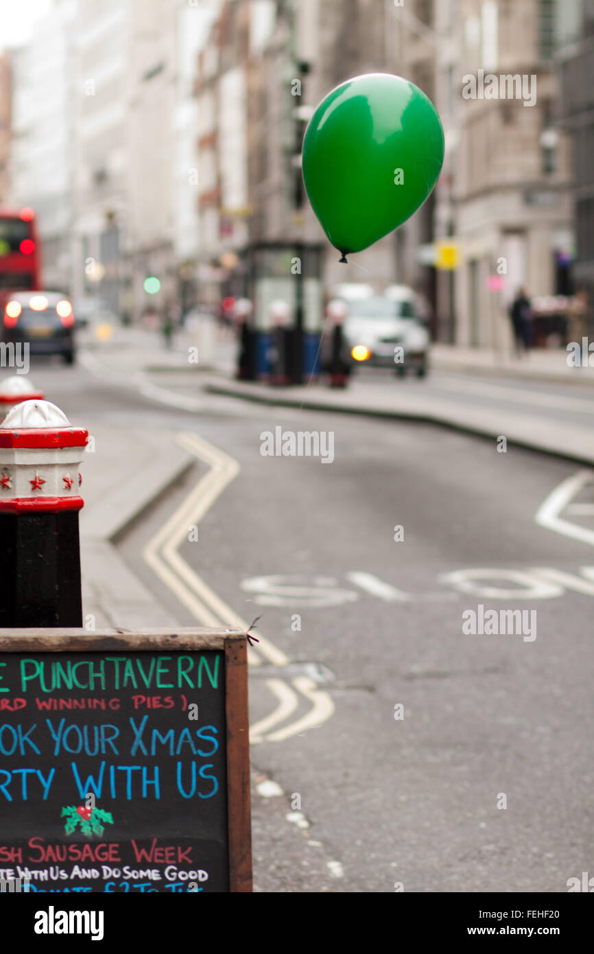 Green balloon tied to sign outside pub on Fleet Street, London Stock Photo