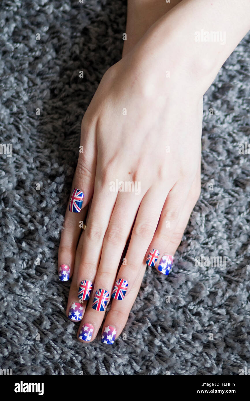 Hands with Union Jack False Nails and Stars and Stripes Nails on a Carpet Stock Photo