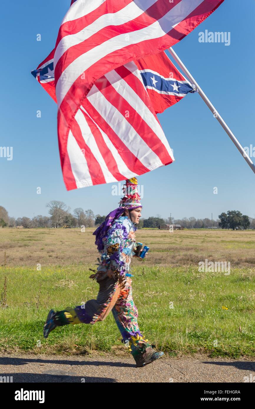 A Cajun Mardi Gras reveler in traditional costume runs through the