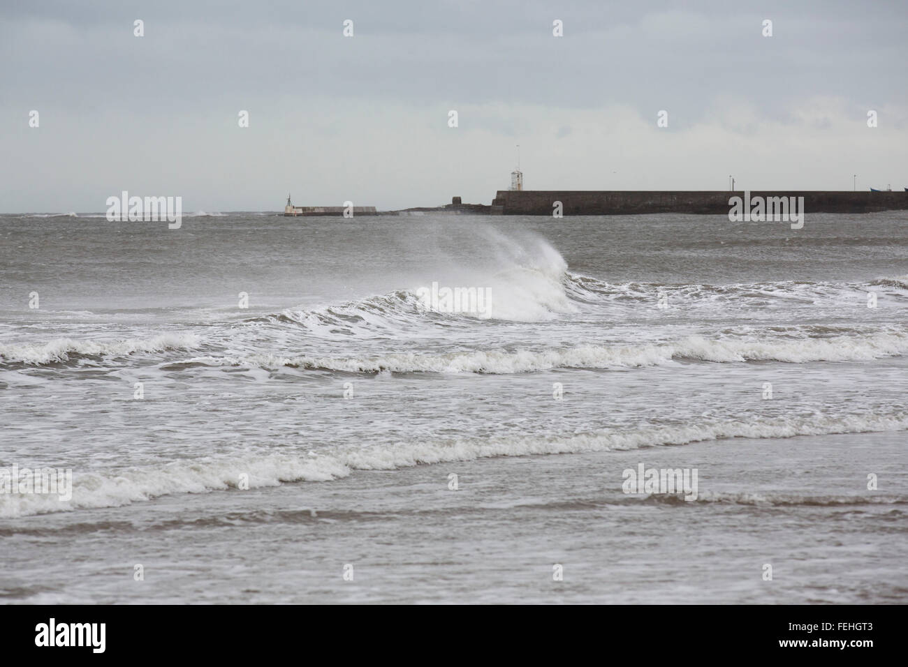 Northumberland, UK. 7th February, 2016. UK Weather: Waves crash by the harbour at North Sunderland in Northumberland, England. The wind whips the tops of the waves. Credit:  Stuart Forster/Alamy Live News Stock Photo