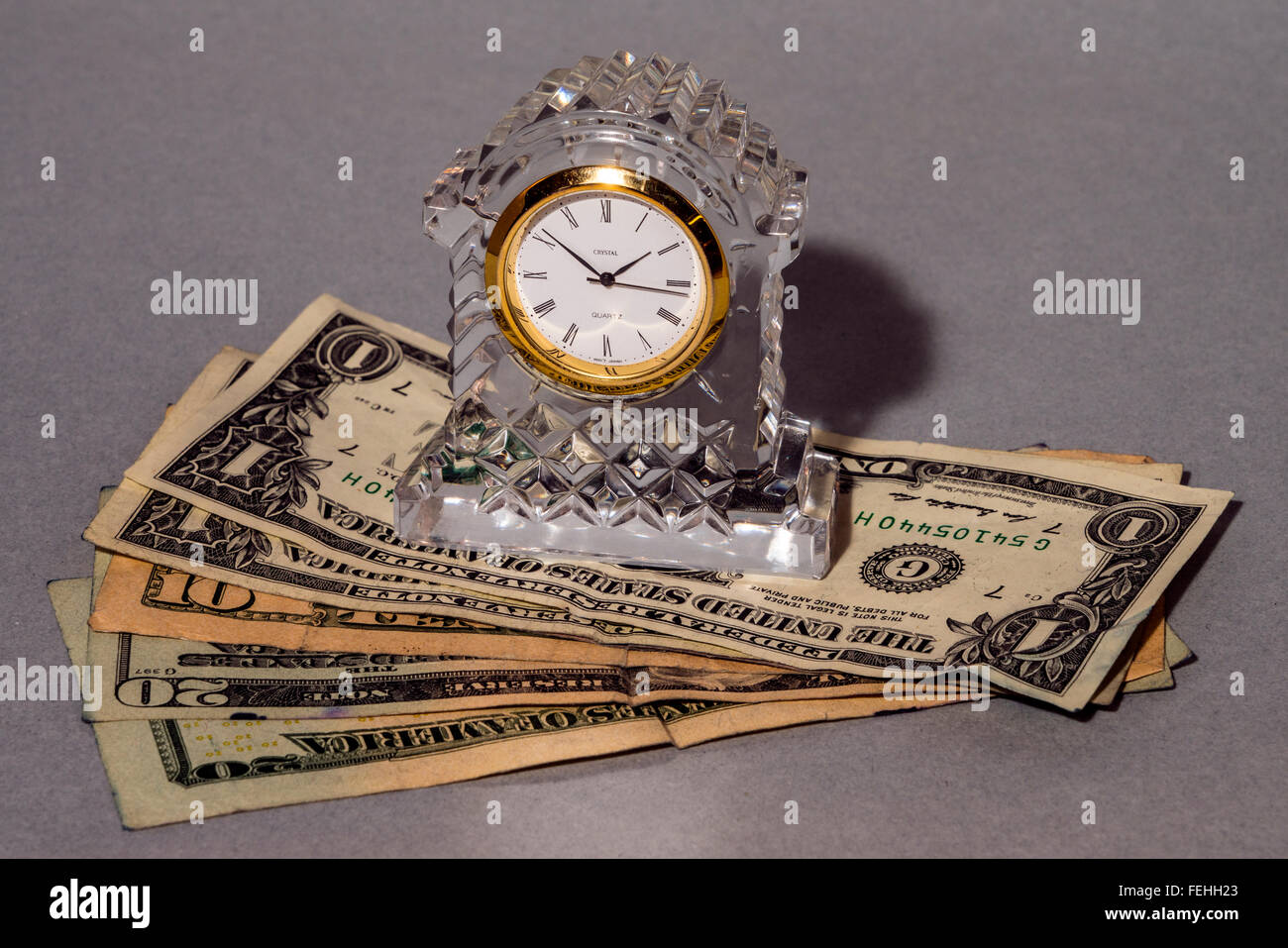 conceptually time means money showing a crystal clock and dollar-bills Stock Photo