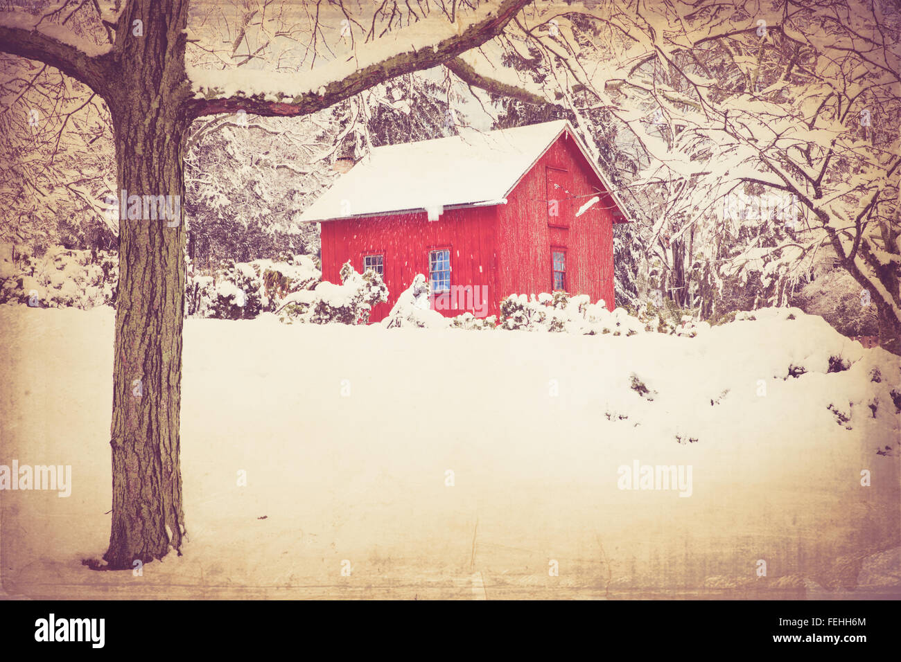 Retro style image of red barn in winter with snow and trees. this image has a vintage texture effect. Stock Photo