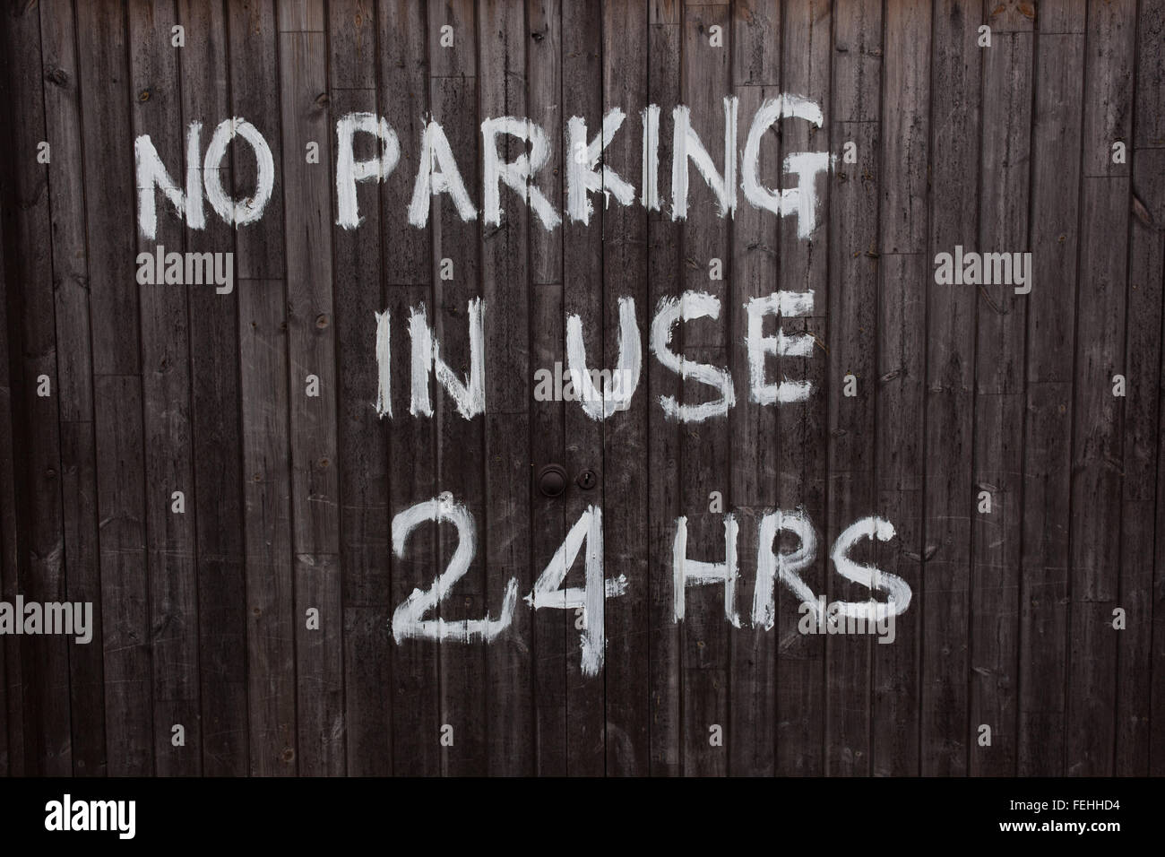 No Parking In Use 24 Hrs Painted In White On Dark Brown