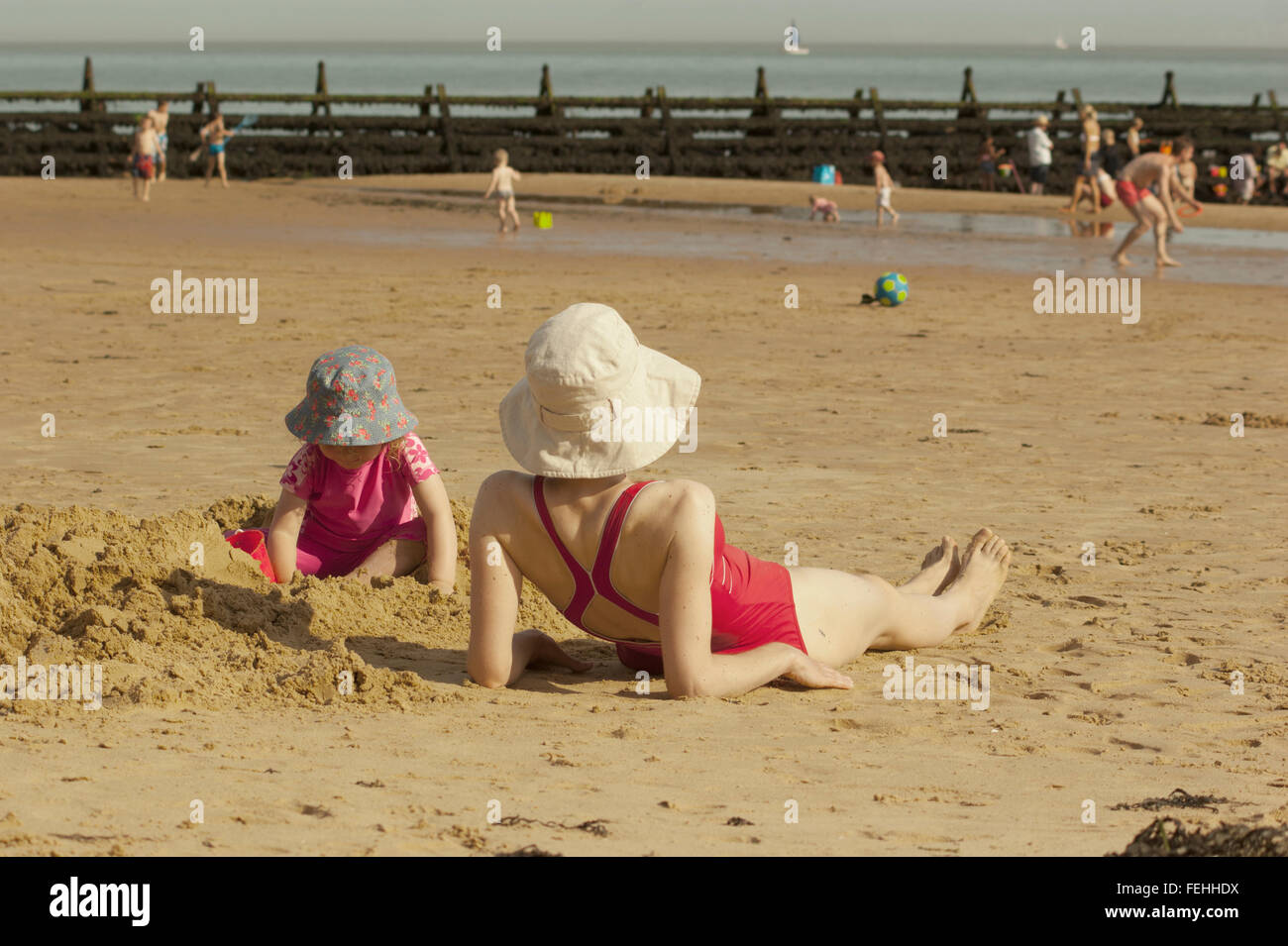 Mother and daughter enjoying the sun on the beach at Walton on the Naze, Essex, UK. Stock Photo