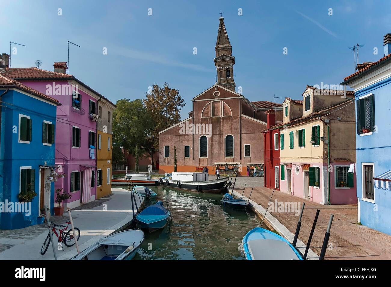 Venice landmark, Burano island canal, colorful houses, church and boats, Italy. Stock Photo