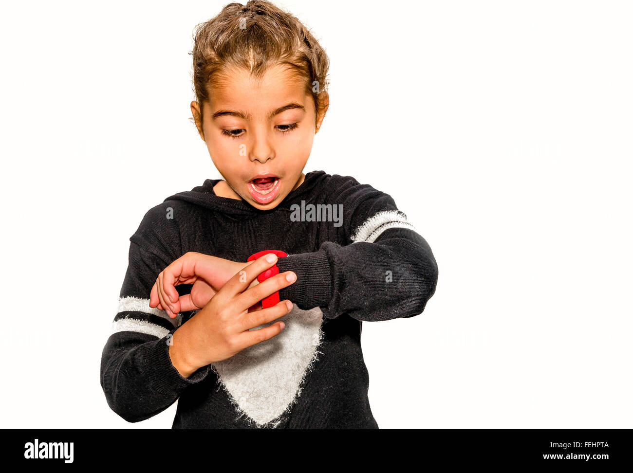 Eight year old girl looking at her watch surprised at what time it is