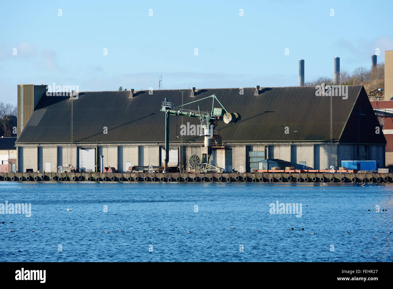 Karlshamn, Sweden - February 04, 2016: An industrial area in the harbor of Karlshamn. Here is an old storage building with a cra Stock Photo