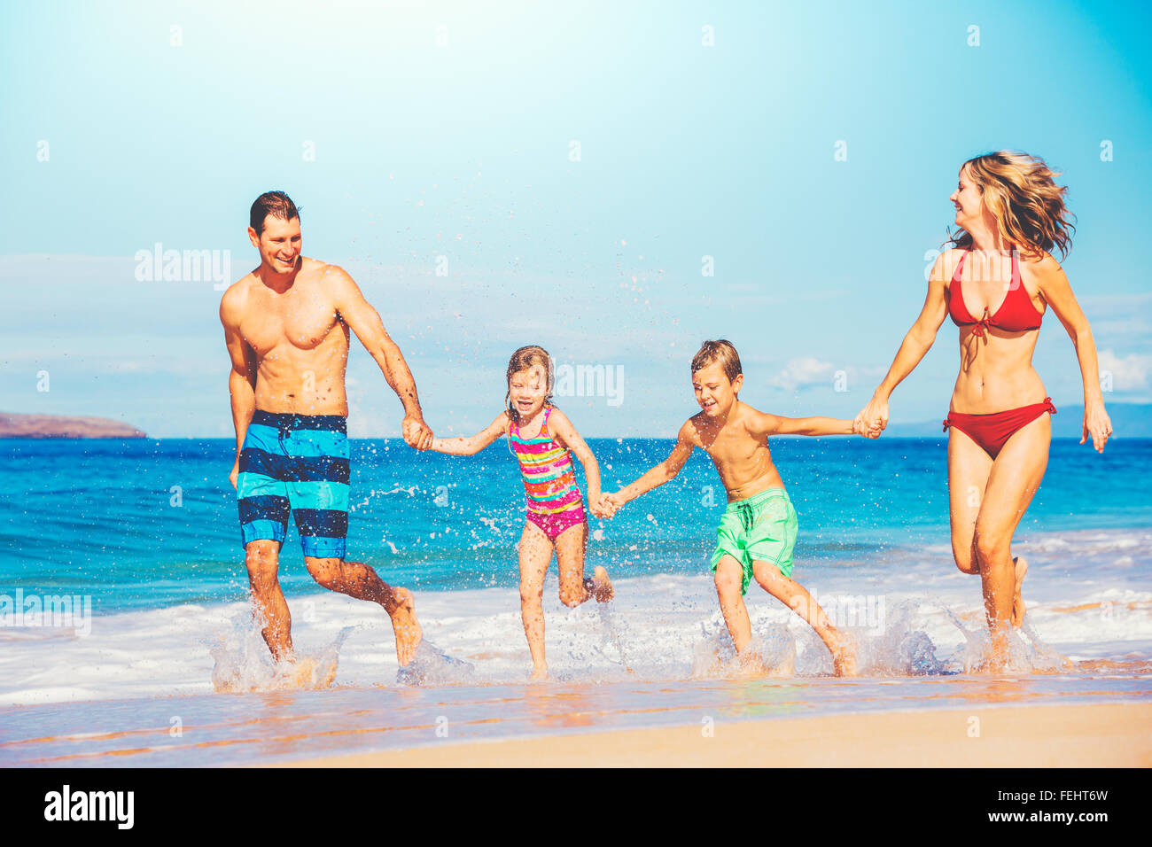 Happy family having fun on beautiful warm sunny beach. Stock Photo
