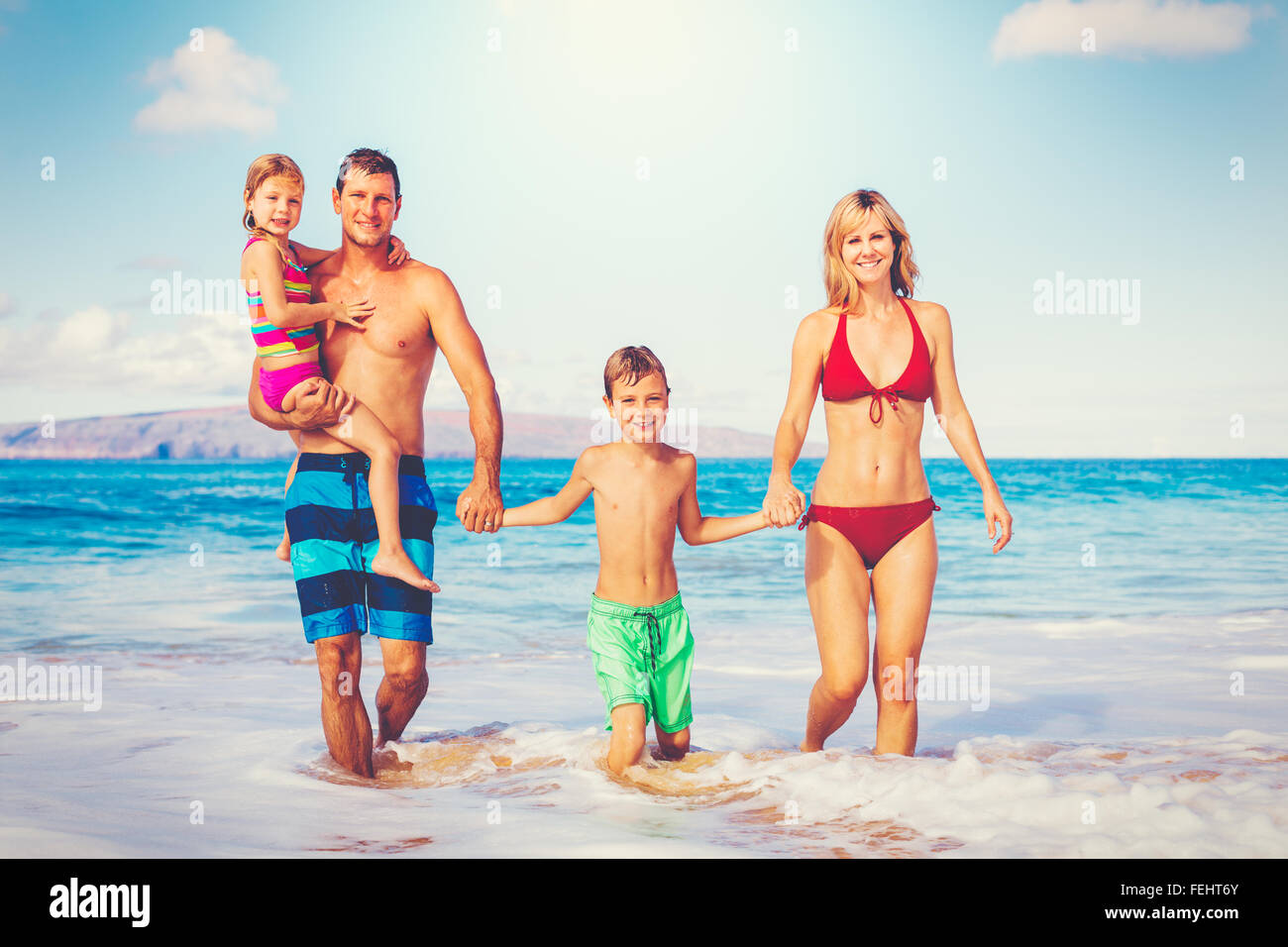 Family vacation. Happy family having fun on beautiful warm sunny beach. Outdoor summer lifestyle. Stock Photo