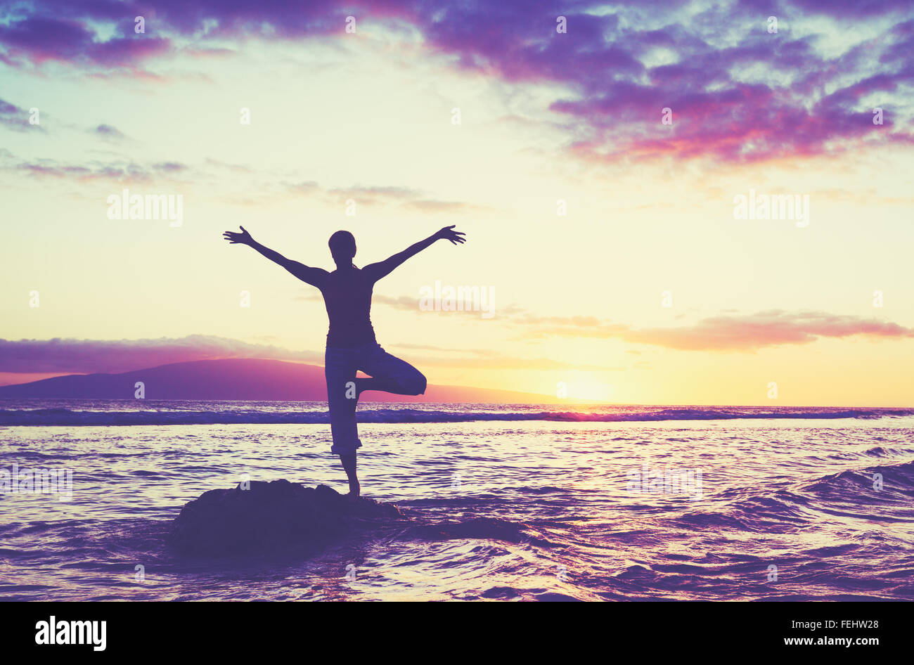 Silhouette of a beautiful yoga woman at sunset, Healthy active lifestyle Stock Photo