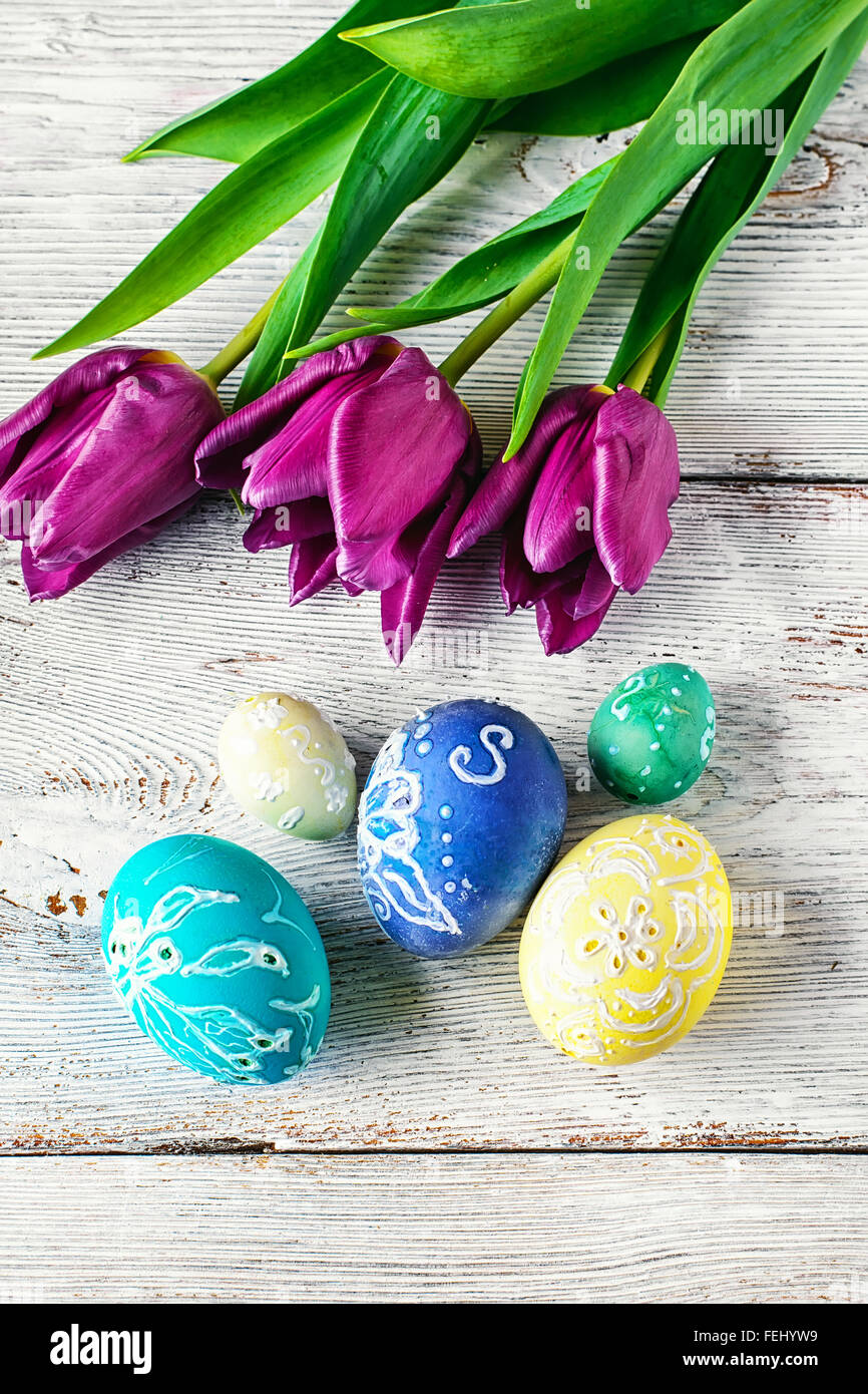 Decorated with painted Easter eggs and flowers on a light background ...