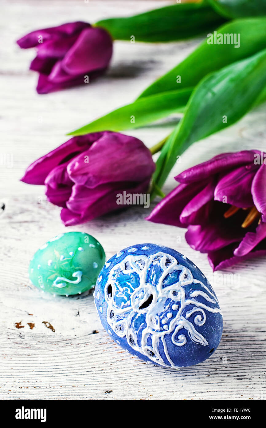 Decorated with painted Easter eggs and flowers on a light background ...