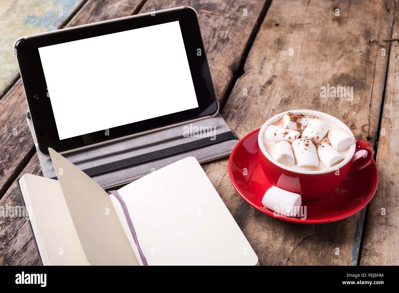 Mock-up with white screen on tablet PC, blank sheets of notebook and cup of hot chocolate with marshmallow Stock Photo