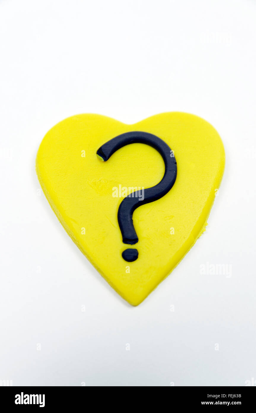 Yellow heart with question mark made from Play-doh. Stock Photo