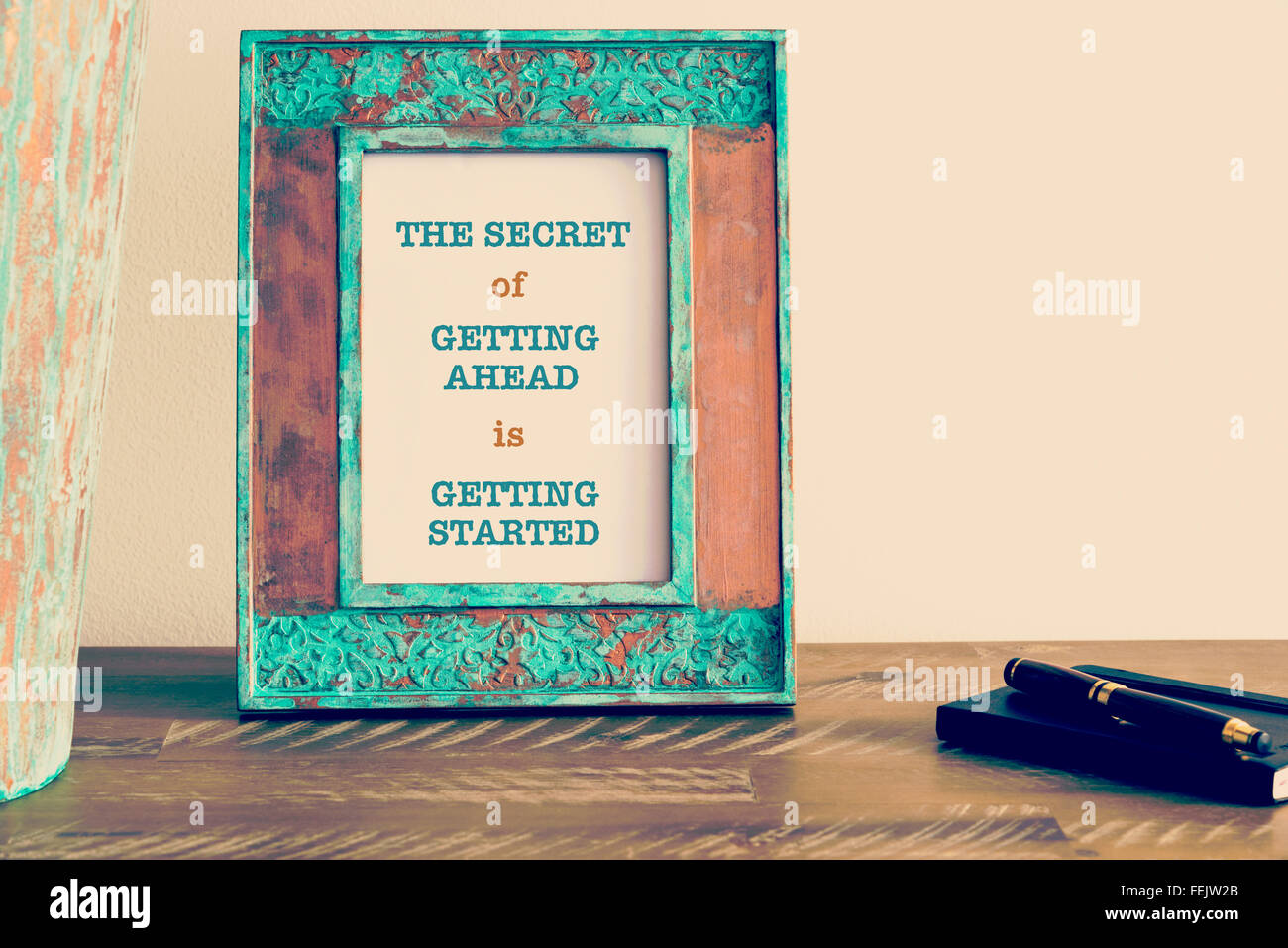Retro effect and toned image of a vintage photo frame next to fountain pen and notebook . Motivational quote written with typewr Stock Photo