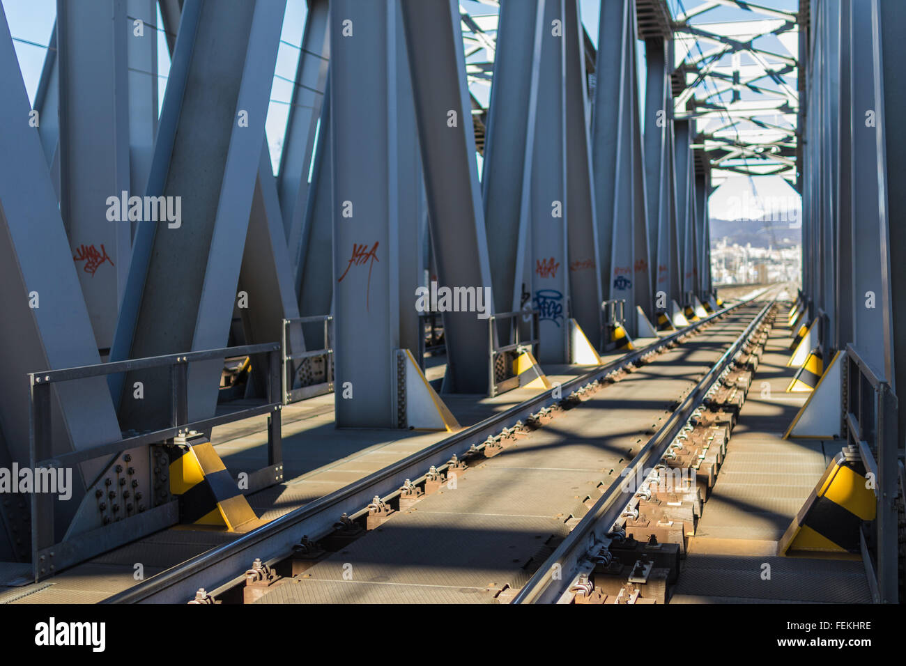 Inside view of big steel railway bridge on sunrise. Selective focus. Stock Photo