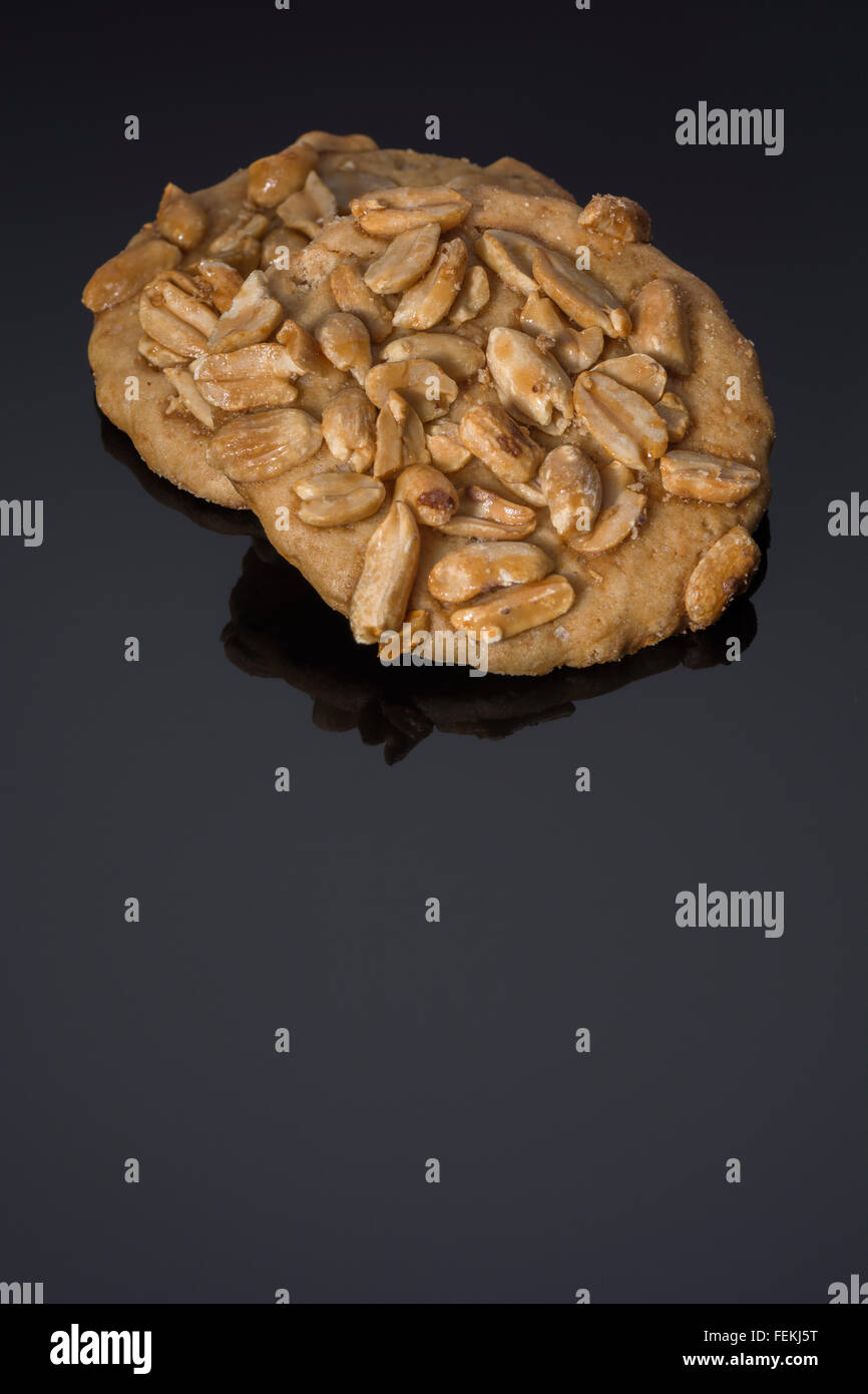 Biscuits / cookies on plain black, reflective, background metaphor