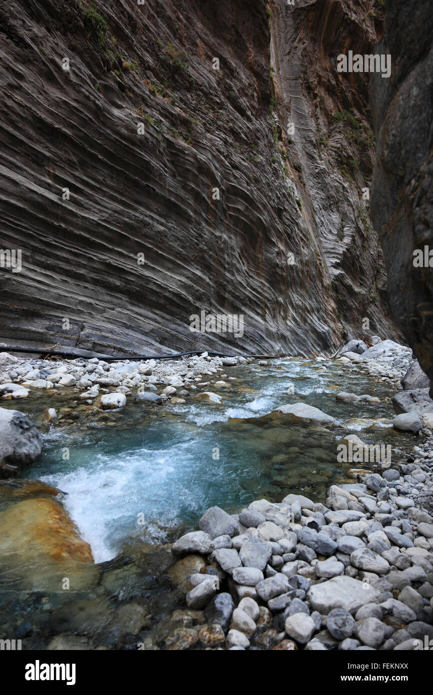 Crete, scenery in the Samaria gulch, fluent brook and high, gruff cliff faces Stock Photo