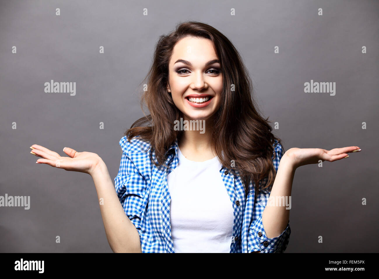 Surprised young woman over gray background Stock Photo - Alamy
