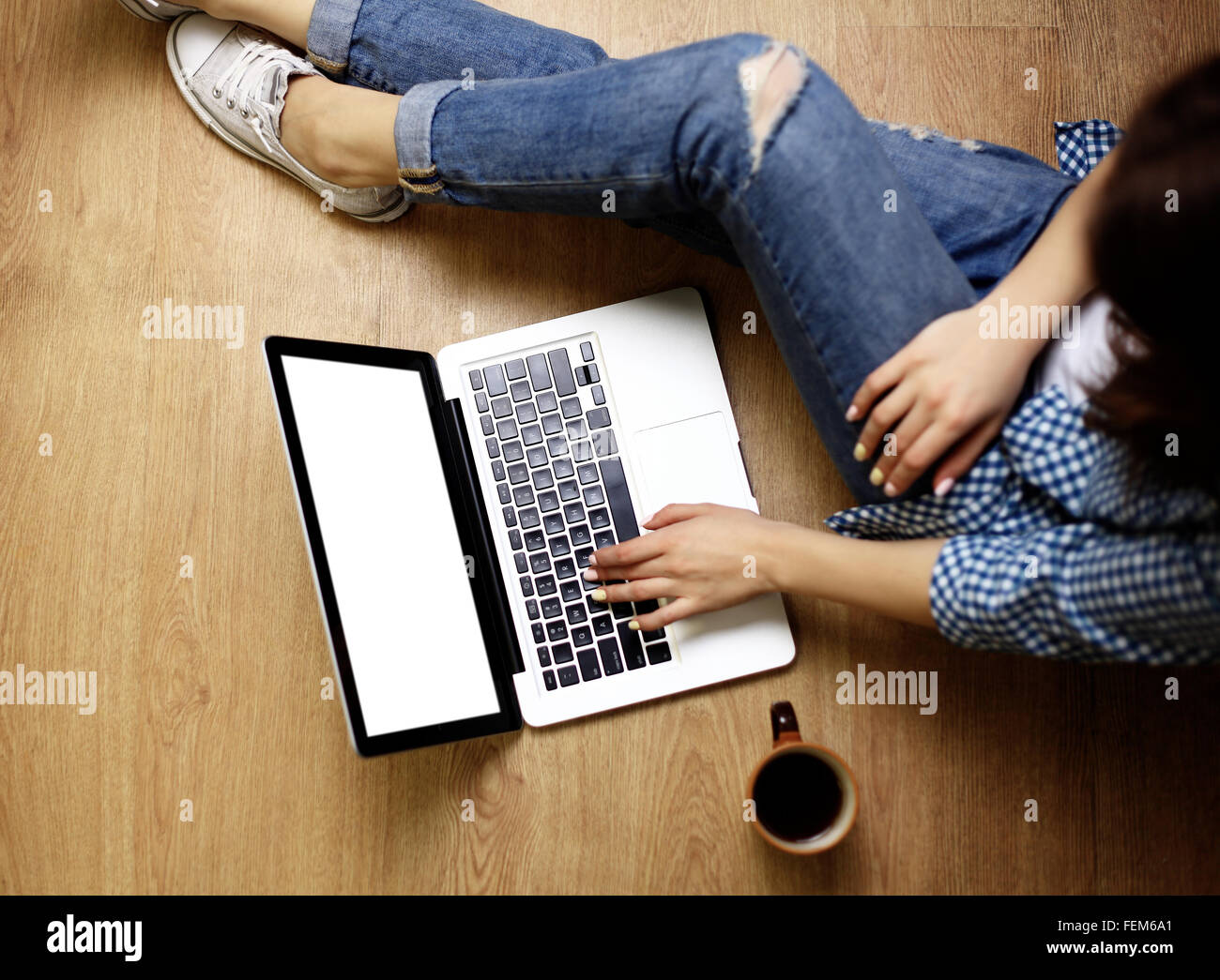 Laptop in girls hands typing and sitting on a wooden floor Stock Photo ...