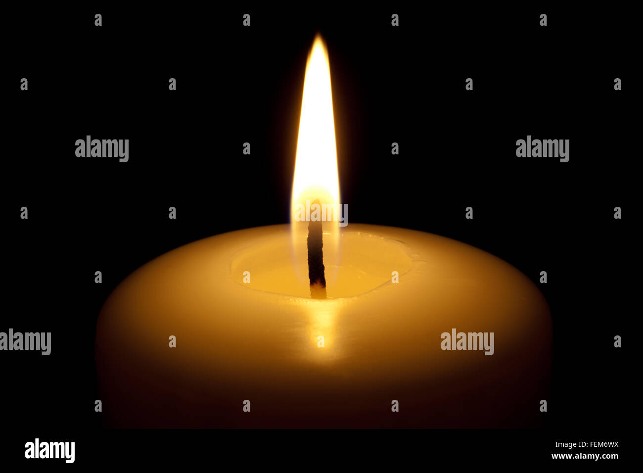 Burning candle, isolated on the black background. Stock Photo