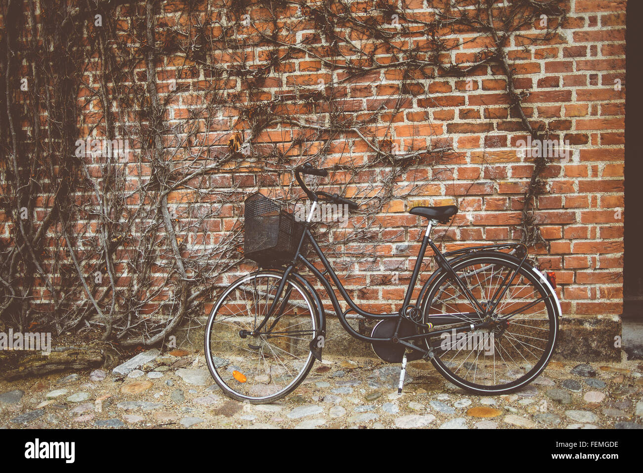 Vintage bicycle leaning on the wall, retro toned image Stock Photo