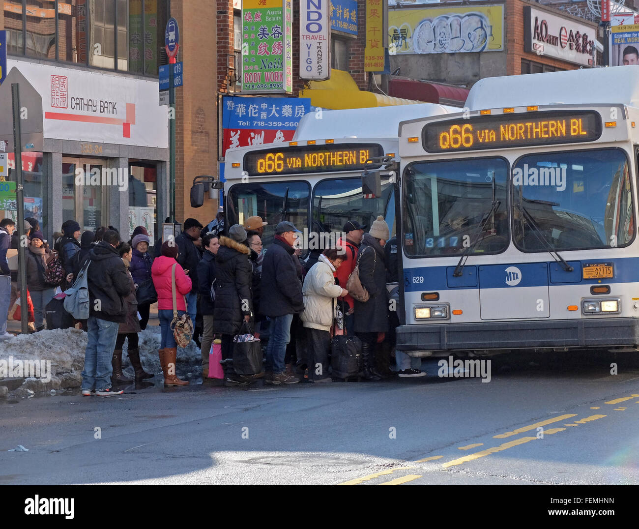 Men and women commuters boarding the Q66 bus on Main Street in Downtown Flu...