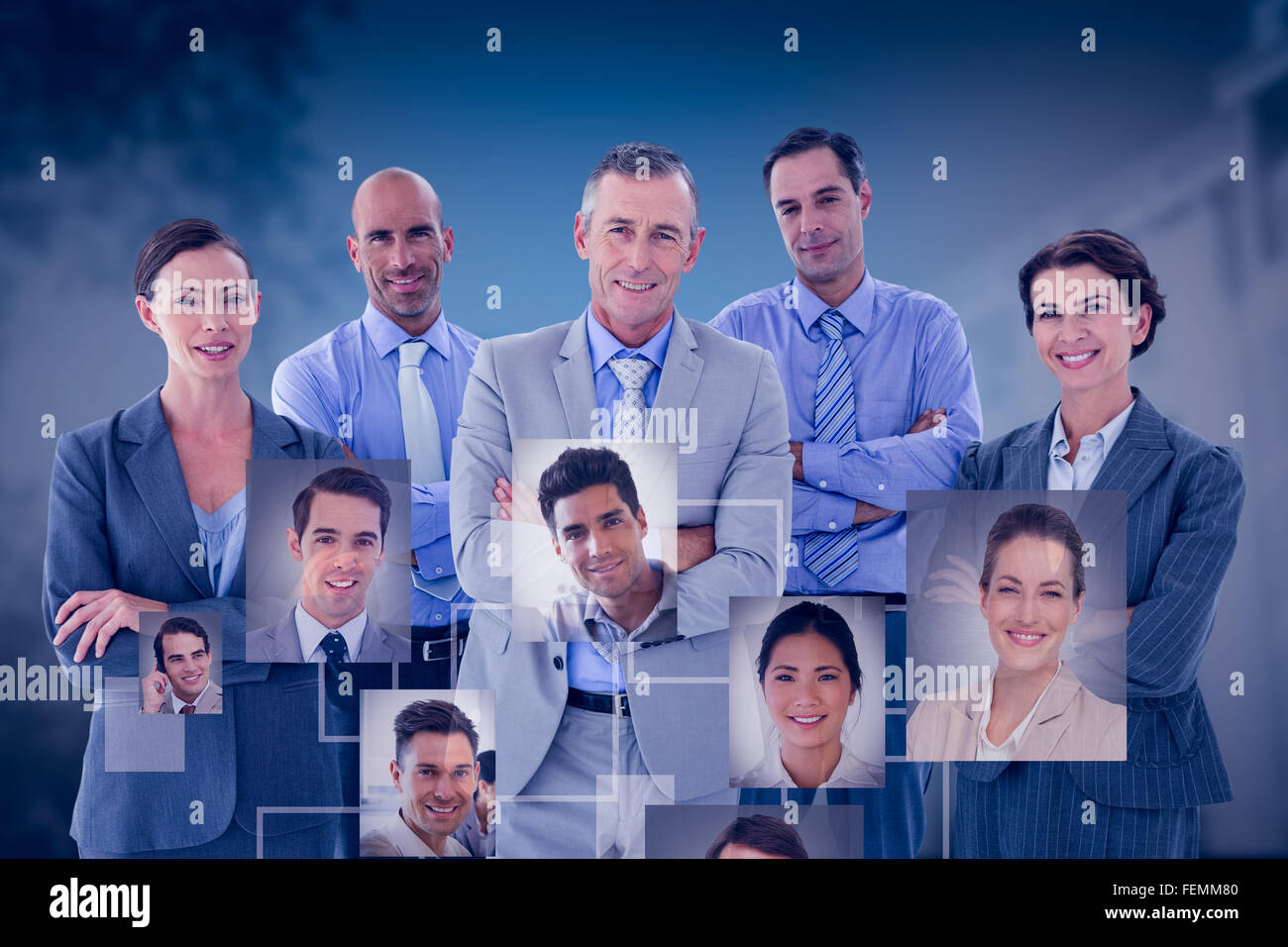 Composite image of business team working happily together on laptop Stock Photo