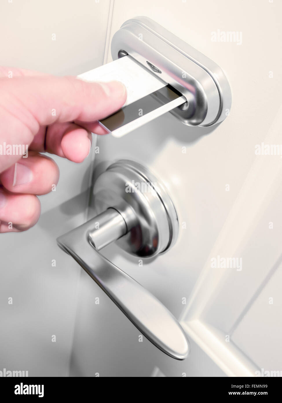 A person's hand unlocking an electronic keycard door lock on a hotel room. Stock Photo