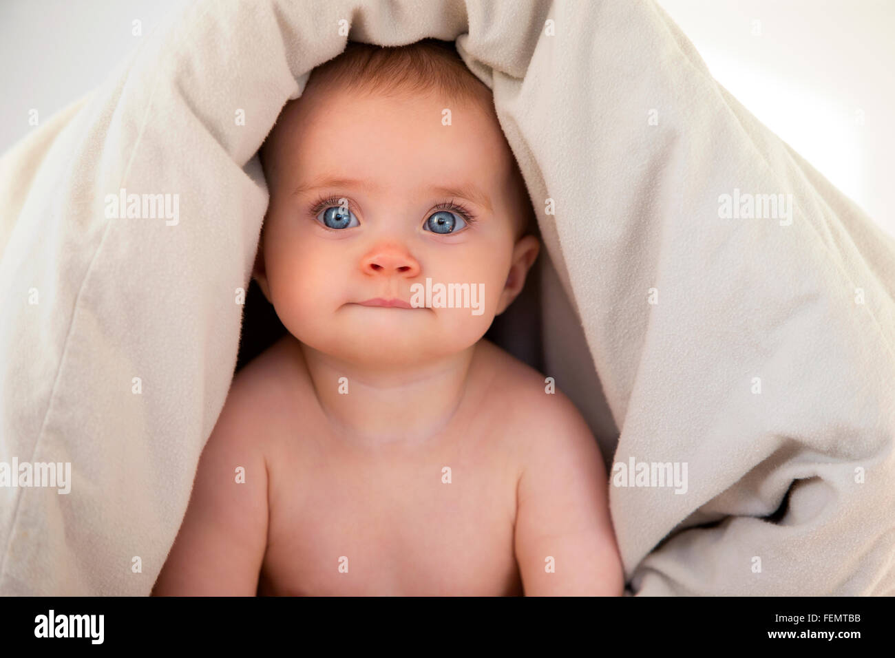 Baby looking from underneath a duvet Stock Photo Alamy