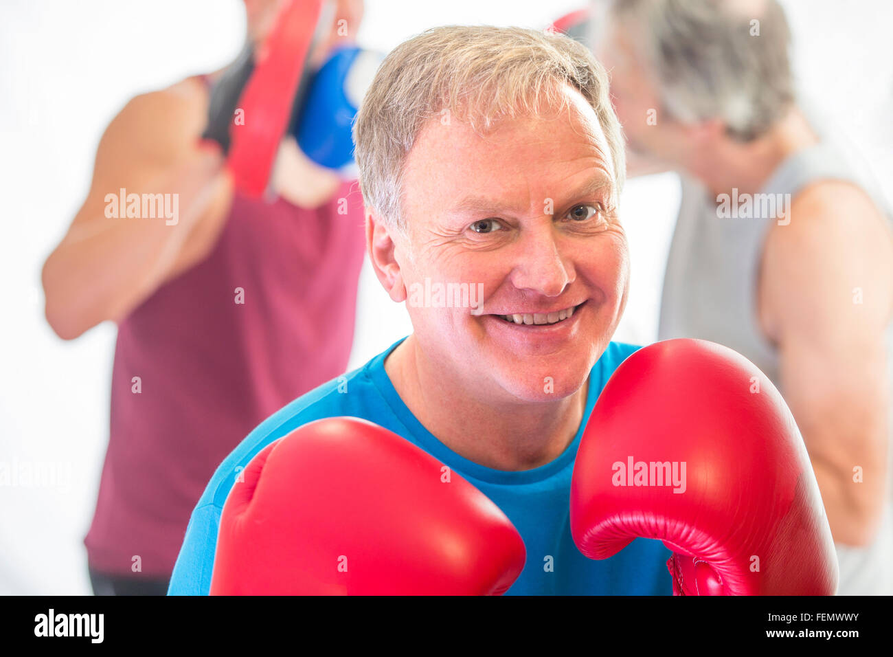 Senior man posing posing in a fighting stance with boxing gloves Stock