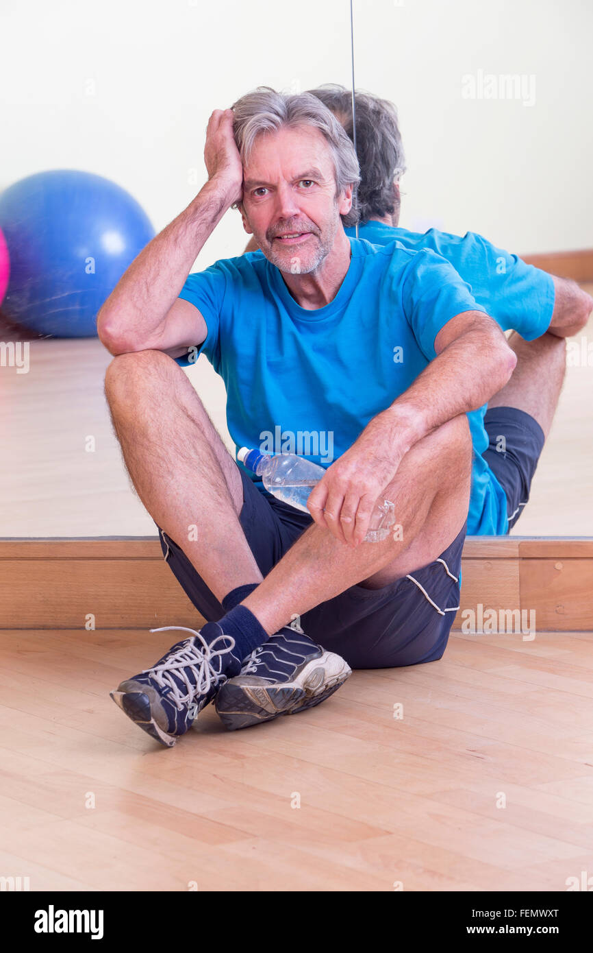 Senior man relaxing after his workout in the gym Stock Photo